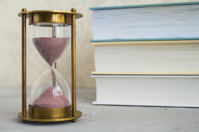 Hourglass with a stack of 3 books