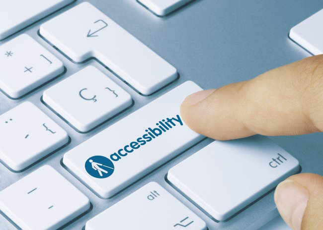 Accessibility Written on Blue Key of Metallic Keyboard. Finger pressing key